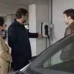 Trois hommes examinant une borne de recharge électrique